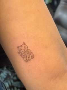 a small cat tattoo on the arm