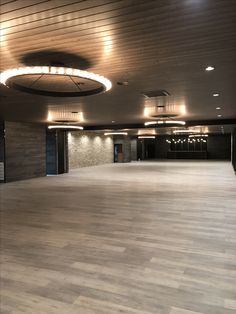 an empty room with wooden floors and lights on the ceiling is pictured in this image