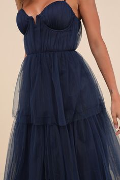 Making it an evening to remember is simple with a grand look like the Lulus Unforgettable Poise Navy Blue Tulle Bustier Tiered Maxi Dress! Airy, sheer tulle-mesh fabric shapes a bustier-style bodice with lightly gathered detailing throughout, padded cups with supportive underwire, and a sweetheart neckline (with a notched V-bar at the center), all supported by adjustable spaghetti straps. The high, fitted waist tops a tiered maxi skirt with a ballgown-inspired silhouette that will gracefully swe Elegant Blue Tulle Fabric For Evening, Blue Tulle Dress, Tiered Maxi Skirt, Blue Tulle, Cup Sizes, Tiered Maxi Dress, Dance Floor, Tulle Dress, Mesh Fabric