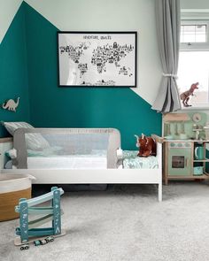 a child's bedroom with green walls and white furniture