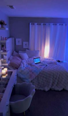 a laptop computer sitting on top of a bed in a room with candles and lights