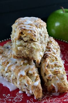 there are several scones on the red plate next to an apple