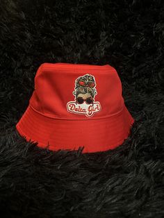 Introducing our new sorority themed bucket hat! Stay shaded in new style, with our Delta Sigma Theta Sorority-inspired custom bucket hat! Made from comfortable and durable cotton & fabric, this hat features a "delta girl" patch on the front to represent your love for the organization. With one size that fits all, this hat is sure to be a great addition to your collection for any outdoor event or everyday use. Great for gifting, cookouts, soror/frat events, casual wear, & much more. Red Summer Bucket Hat (one Size Fits Most), Cheap Red Bucket Hat With Curved Brim, Sorority Bucket Hat, Red Bucket Hat For Streetwear, Adjustable Red Bucket Hat, Custom Bucket Hats, Girl Patches, Delta Girl, Delta Sigma Theta Sorority