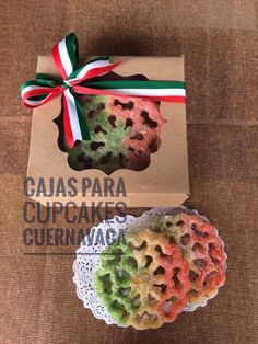 two colorful cookies are in a box with a bow on it's neck and the packaging is open