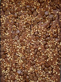 a chocolate cake with nuts and almonds on top, ready to be baked in the oven