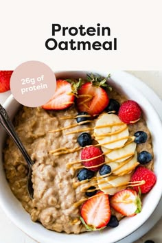 a bowl of oatmeal with strawberries and blueberries on the side