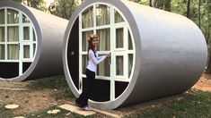 a woman standing in front of two round shaped windows