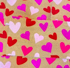 several hearts are painted on brown paper with pink and red colors in the shape of heart shapes