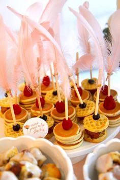 mini waffles are topped with fruit and feathers