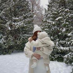 a woman holding a baby in the snow