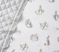 an image of a bed with peter rabbit wallpaper