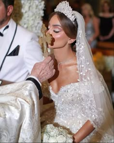 a bride and groom are getting married at their wedding ceremony with the priest looking on