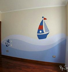 a child's room painted in blue and red with a sailboat on the wall