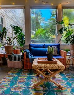 a living room filled with lots of plants and furniture