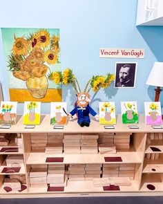 an assortment of sunflowers are on display in front of pictures and cards for sale