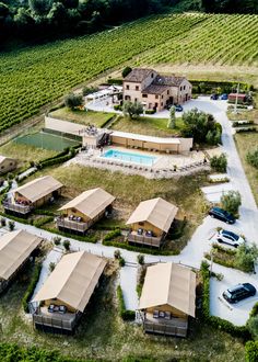 an aerial view of several tents and cars parked in front of a vineyard with a swimming pool