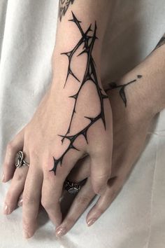 two hands with barbed wire tattoos on them