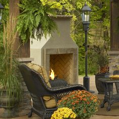 an outdoor fireplace and seating area with potted plants