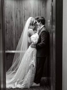 a bride and groom kissing in an elevator