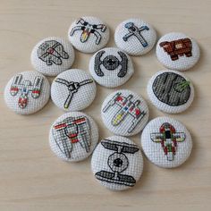 nine embroidered buttons with different types of sewing related items in them on a wooden surface