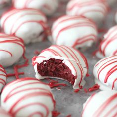 red velvet cake balls with white frosting and sprinkles on the surface