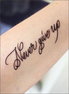 a tattoo that says never give up on the arm and it is written in cursive writing