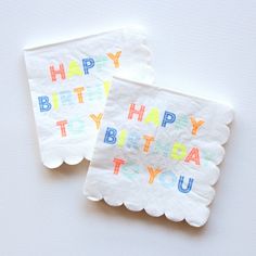 two napkins with the words happy birthday to you printed on them, sitting next to each other