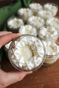 a person holding a glass jar filled with whipped cream