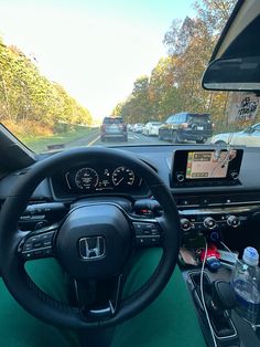 the interior of a car with dashboard, steering wheel and other items on the road