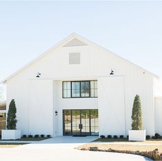 a white barn with black doors and windows