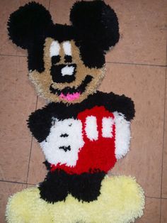 two mickey mouse rugs on the floor with one holding a red and white heart