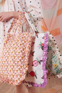 a close up of a person holding two bags with flowers on them and polka dots