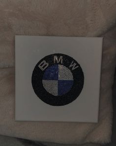 the bmw emblem is on top of a white pillow