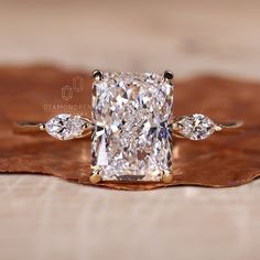 a cushion cut diamond ring with three pear shaped diamonds