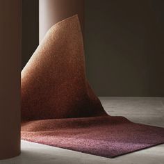 an unusual carpet sits on the floor next to two tall pillars in a dark room