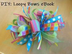 a colorful bow with polka dots and ribbons on top of a wooden table that says diy loopy bows e book