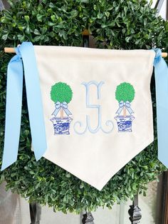 a blue and white banner with two trees on it is hanging from a tree branch