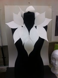 a black and white mannequin with paper flowers on it