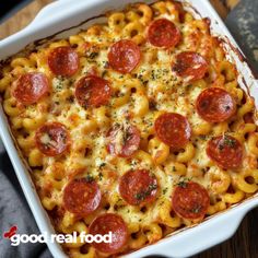 a casserole dish with pepperoni and cheese in it on a wooden table