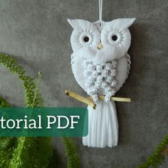 an owl ornament hanging from a tree branch