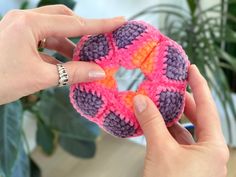 a person holding a crocheted doughnut in their hand, with the ring on it's end