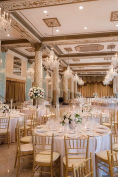 an elegant ballroom with chandeliers, tables and chairs