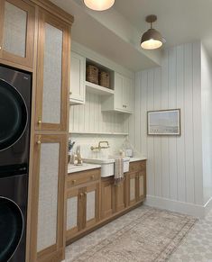 a kitchen with wooden cabinets and white counter tops next to a washer and dryer