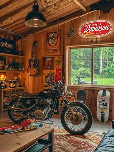 a motorcycle parked inside of a garage next to a table and chair with a guitar on it