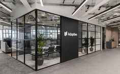 an office with glass walls and plants in it