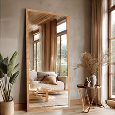 a large mirror sitting on top of a wooden floor next to a couch and table