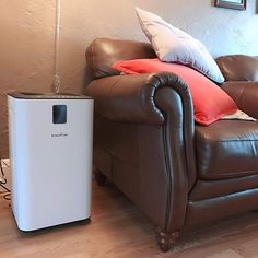 a living room with a brown leather chair and a white air puke heater