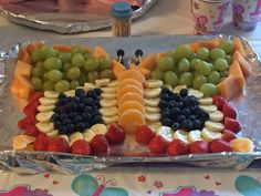 a platter with grapes, strawberries, oranges and grapes on it