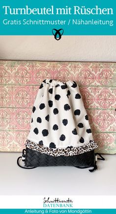 a black and white polka dot bag sitting on top of a table next to a pillow