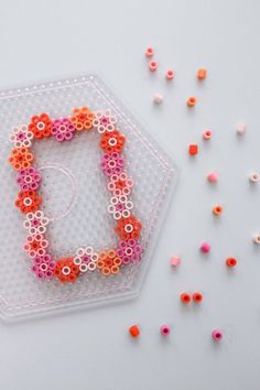 the beaded bracelet is sitting on top of a plastic container with beads scattered around it